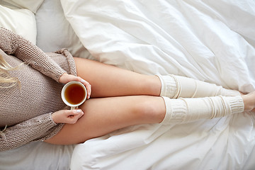 Image showing close up of woman with tea cup in bed