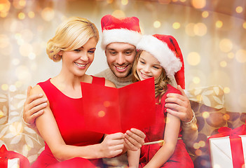 Image showing smiling family reading postcard