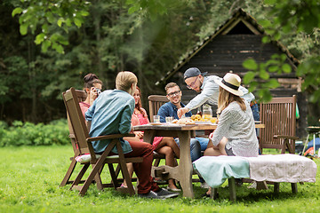 Image showing happy friends having dinner at summer garden party