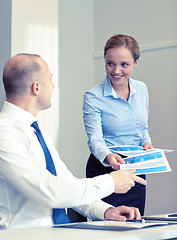 Image showing smiling woman giving papers to man in office