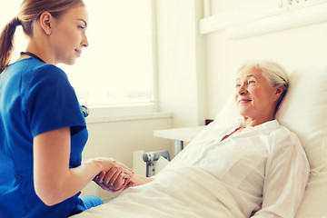 Image showing doctor or nurse visiting senior woman at hospital