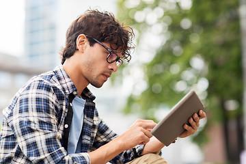 Image showing man with tablet pc sitting on city street bench