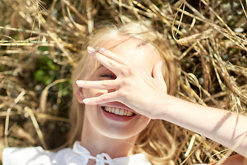 Image showing happy young woman lying on cereal field