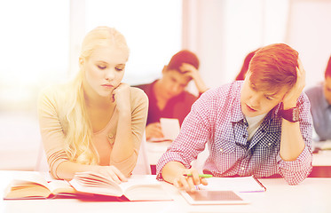 Image showing tired students with tablet pc, books and notebooks