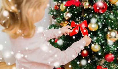 Image showing close up of little girl decorating christmas tree
