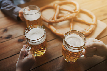 Image showing close up of hands with beer mugs at bar or pub