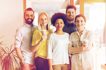 Image showing happy smiling creative team with coffee in office
