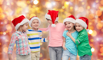 Image showing happy little children in santa hats hugging