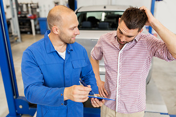 Image showing auto mechanic with clipboard and man at car shop