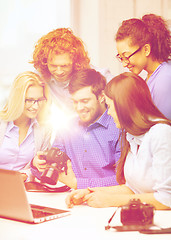 Image showing smiling team with laptop and photocamera in office