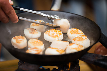 Image showing close up of scallops frying in cast iron pan