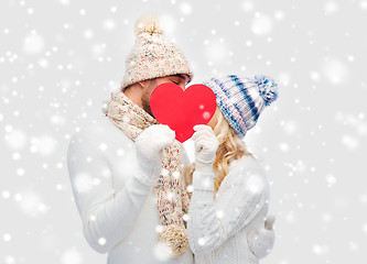 Image showing smiling couple in winter clothes with red heart
