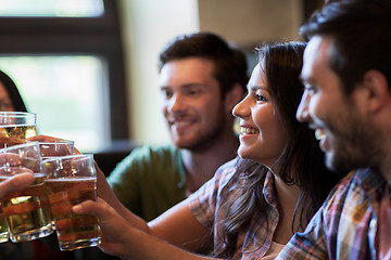 Image showing happy friends drinking beer at bar or pub