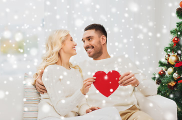 Image showing happy couple with red heart at home for christmas
