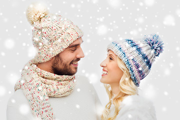 Image showing smiling couple in winter clothes hugging over snow