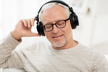 Image showing happy man in headphones listening to music at home