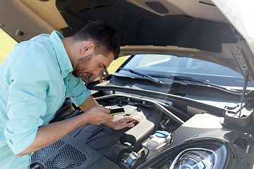 Image showing man with smartphone and broken car at countryside