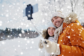 Image showing happy couple taking selfie by smartphone in winter