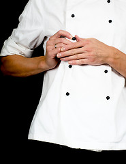 Image showing Professional chef buttoning up a white chefs jacket towards blac