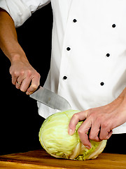 Image showing Professional chef holding a sharp cooking knife onto a whole cab