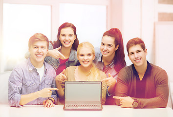 Image showing smiling students pointing to blank lapotop screen