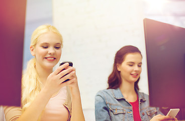 Image showing two teens with smartphones in computer class