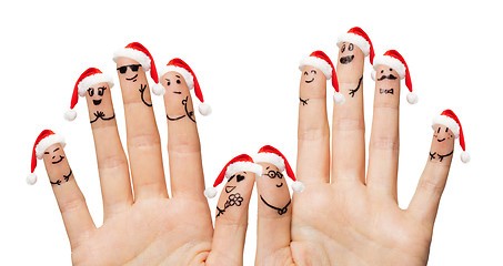 Image showing close up of fingers with smiley in santa hats