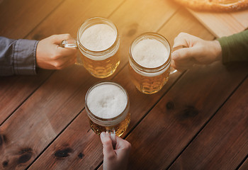 Image showing close up of hands with beer mugs at bar or pub