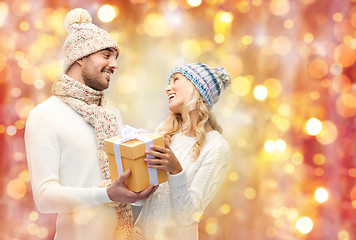 Image showing smiling couple in winter clothes with gift box