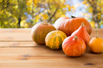 Image showing close up of pumpkins on wooden table outdoors