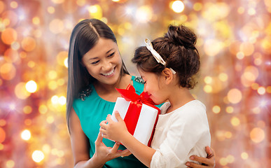 Image showing happy mother and girl with gift box over lights