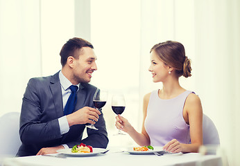 Image showing couple with main course and red wine at restaurant