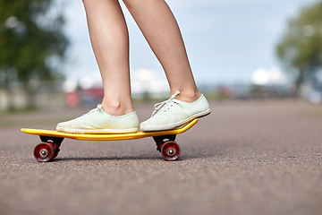 Image showing close up of female feet riding short skateboard