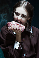 Image showing Bloody Halloween theme: crazy girl with raw meat
