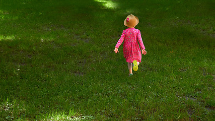 Image showing Happy cute little girl running in the park. Happiness.