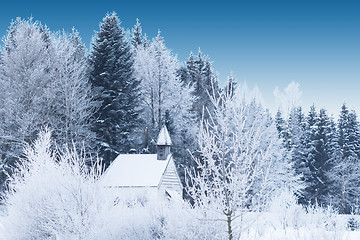 Image showing Snow-capped little wooden chapel in frosty winter forest