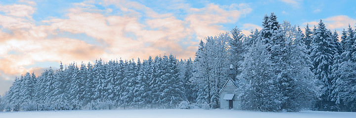 Image showing Panoramic landscape of snowbound forest with frosty small church