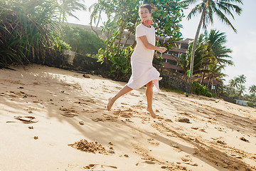 Image showing Woman walking on the beach sand