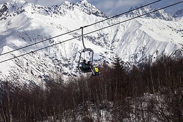 Image showing Skiers on ski-lift in snow mountains at winter sun day