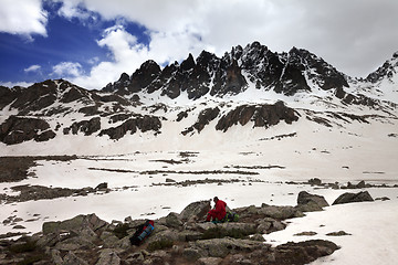 Image showing Hiker with dog resting on halt in snow mountain at gray day