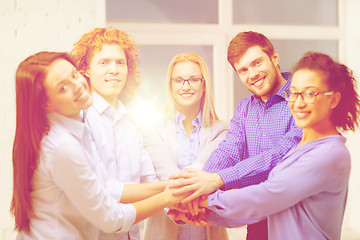 Image showing team with hands on top of each other in office