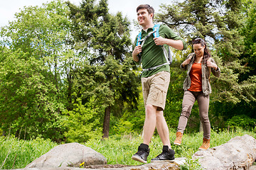 Image showing happy couple with backpacks hiking outdoors