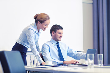 Image showing businessman and secretary with laptop in office