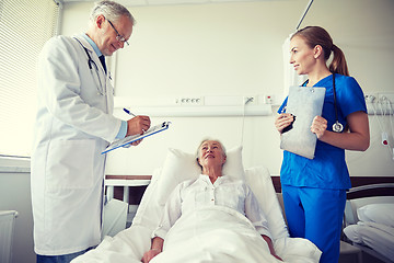 Image showing doctor and nurse visiting senior woman at hospital