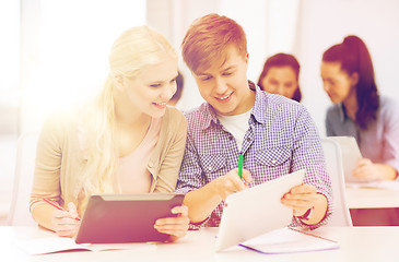 Image showing two smiling students with tablet pc and notebooks