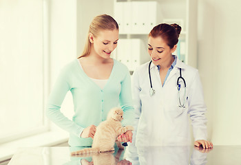 Image showing happy woman with cat and doctor at vet clinic