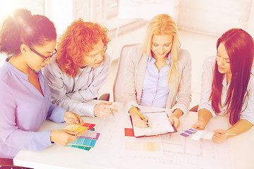 Image showing team with color samples and blueprint at office