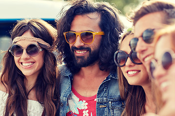 Image showing smiling young hippie friends over minivan car