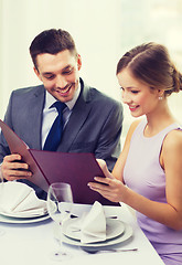 Image showing smiling couple with menu at restaurant