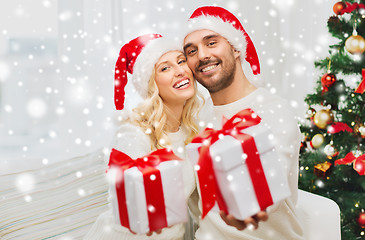 Image showing happy couple at home with christmas gift boxes